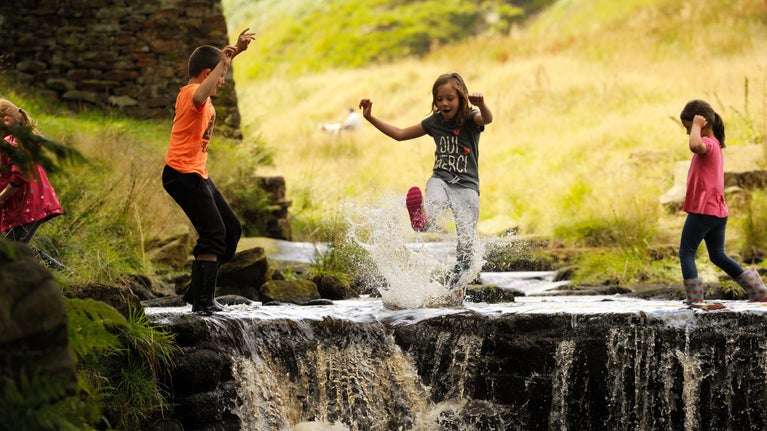 Children paddling in a stream at Eastergate on the Marsden Moor Estate, West Yorkshire
